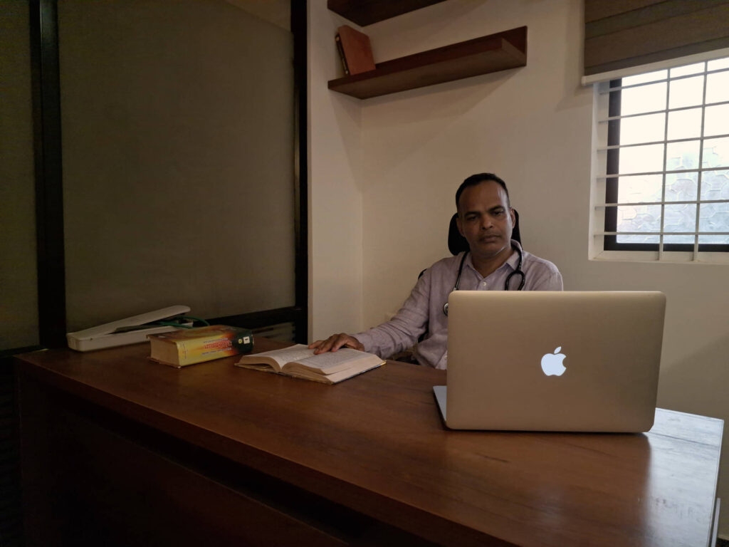 Photo of Dr. Anil Rai MD (Ayu), inner health consultant conducting-online ayurvedic consultation via laptop in his clinic. 